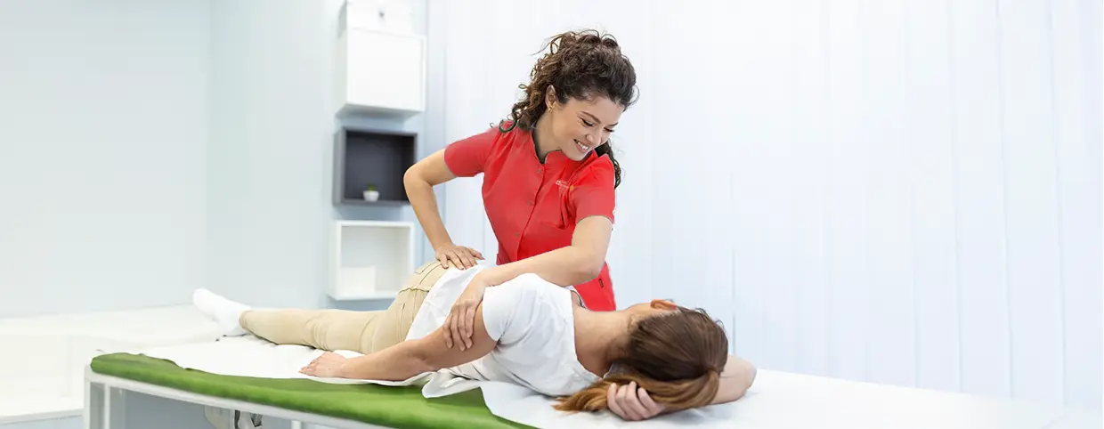 Physiotherapist providing treatment for sports injuries to a woman