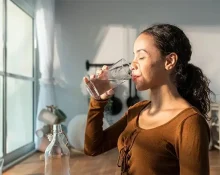 A young girl drinking water to get rid of the flu