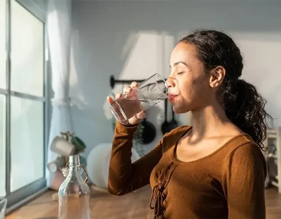 A young girl drinking water to get rid of the flu